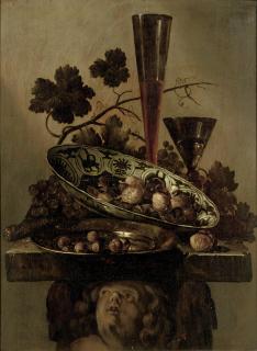 Abraham Susenier - A porcelain bowl with walnuts, a pewter dish with hazelnuts and a \'Façon de Venise\', all on a cherub styled pedestal