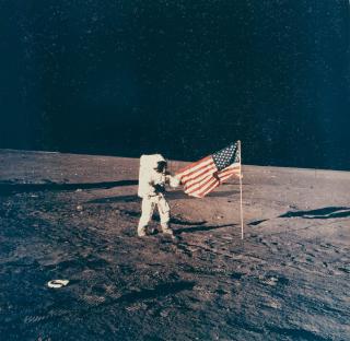 Alan Bean - Apollo 12: Charles Conrad Jr. next to the American flag.
