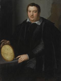 Alessandro Allori - Portrait Of A Gentleman, Three-Quarter Length, Dressed In A Black Silk Doublet And Cloak With A Blackwork Collar And Seated At A Desk, Holding An Oval Frame