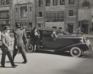 Alfred Eisenstaedt - Chauffeur holding door for matronly woman stepping on to sidewalk on Fifth Avenue in midtown, New York, NY, 1942