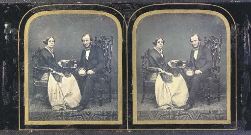 Antoine Claudet - Woman and man seated by a table, together holding cased photograph (possibly stereograph) and man holding magnifying glass, 1850s