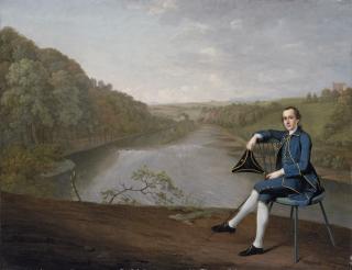Arthur Devis - Portrait of Philip Howard of Corby Castle, Cumberland, small full-length, in a blue coat, seated holding a tricorn hat in his right hand, on the banks of the River Eden, Corby Tower beyond