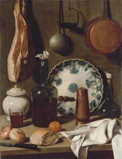 Carlo Magini - A glass bottle, a blue and white porcelain platter, a copper coffee pot, a flask, a covered jar, a tumbler of wine, a knife, bread, onions and an orange on a partially-draped table, with a ham and pans suspended from the wall