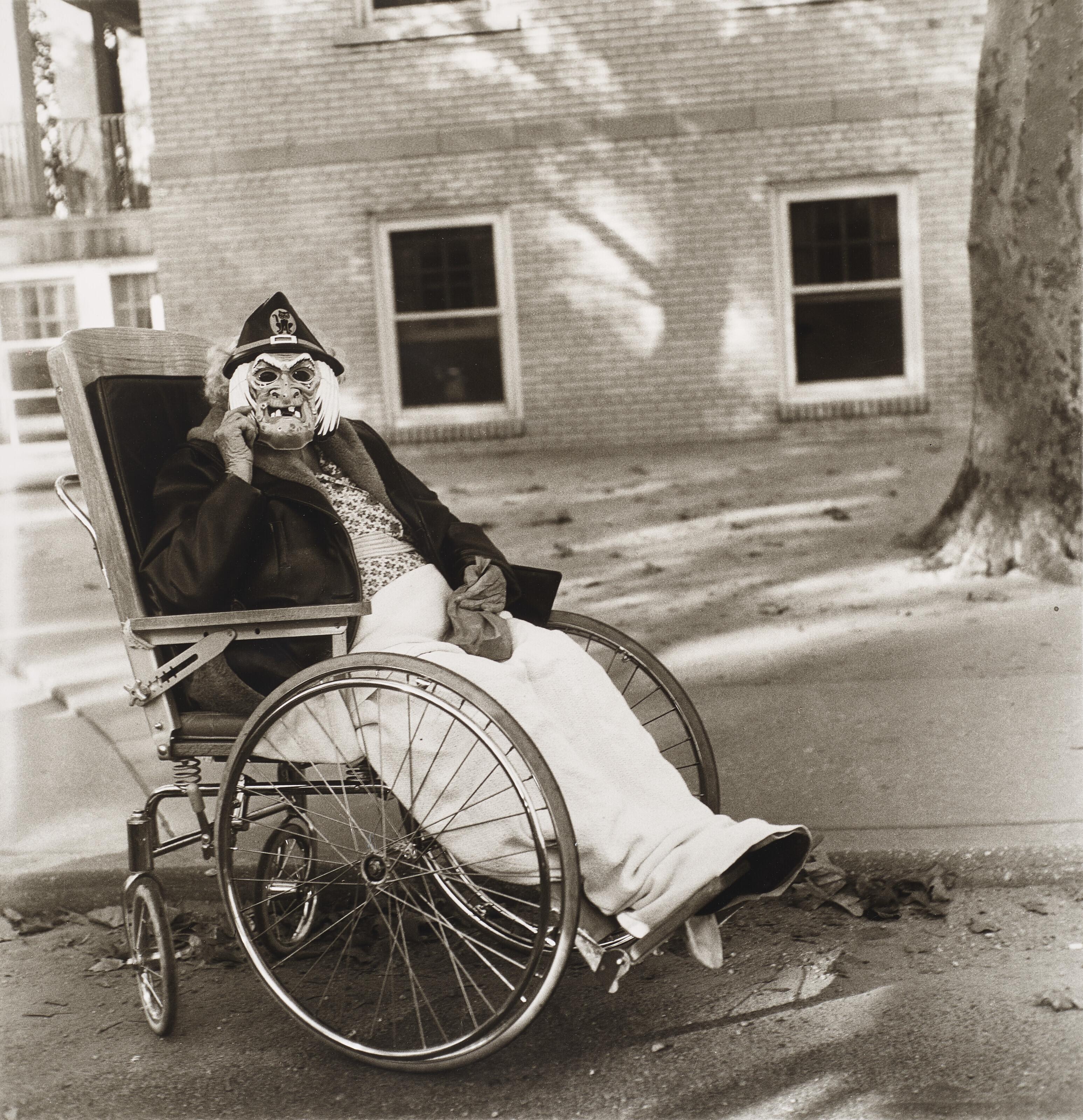 Diane Arbus - Masked woman in a wheelchair, PA, 1970