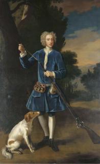 Enoch Seeman - Portrait of a gentleman, full-length, in a blue velvet coat, loading his gun, a spaniel at his side, in a landscape