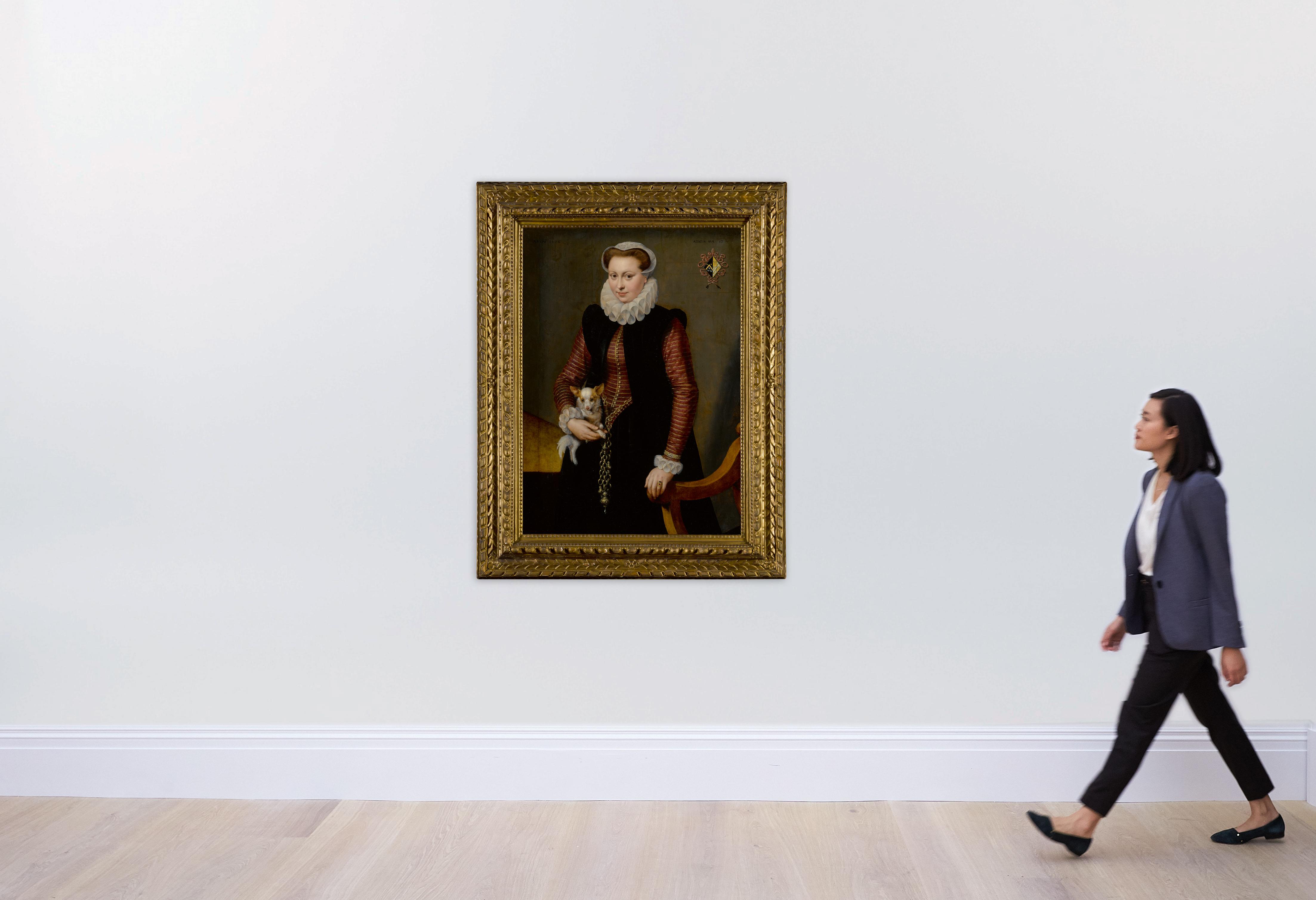 Frans Pourbus The Elder - Portrait of a young woman, aged 17, holding a small spaniel wearing a collar of bells