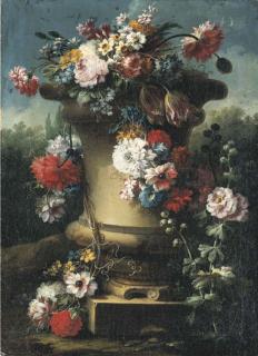 Gasparo López - Narcissi, tulips, chrysanthemums, roses and other flowers in a stone urn with hollyhocks, a wooded landscape beyond