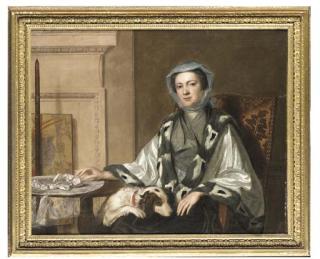 George Knapton - Portrait of Mrs Neate, of Donnington, Hampshire, half-length, in an embroidered silver shawl trimmed with fur, seated by a table with a spaniel her lap, in an interior, beside a polescreen