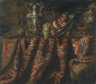 Jacques Hupin - A Still Life With Pomegranates, And Grapes On A Table Draped With An Ornate Turkish Carpet And Assorted Orfèvrerie