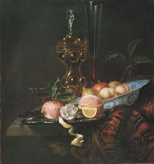 Juriaen Van Streek - Peaches and a lemon in a Wanli \'kraak\' porselein bowl, a partly peeled lemon, an orange slice, a pomegranate and bread on a pewter plate, a gilt cup and cover and a wine flute on a partly draped table