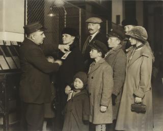 Lewis W. Hine - A Family At Ellis Island, New York Getting Tagged By An Official