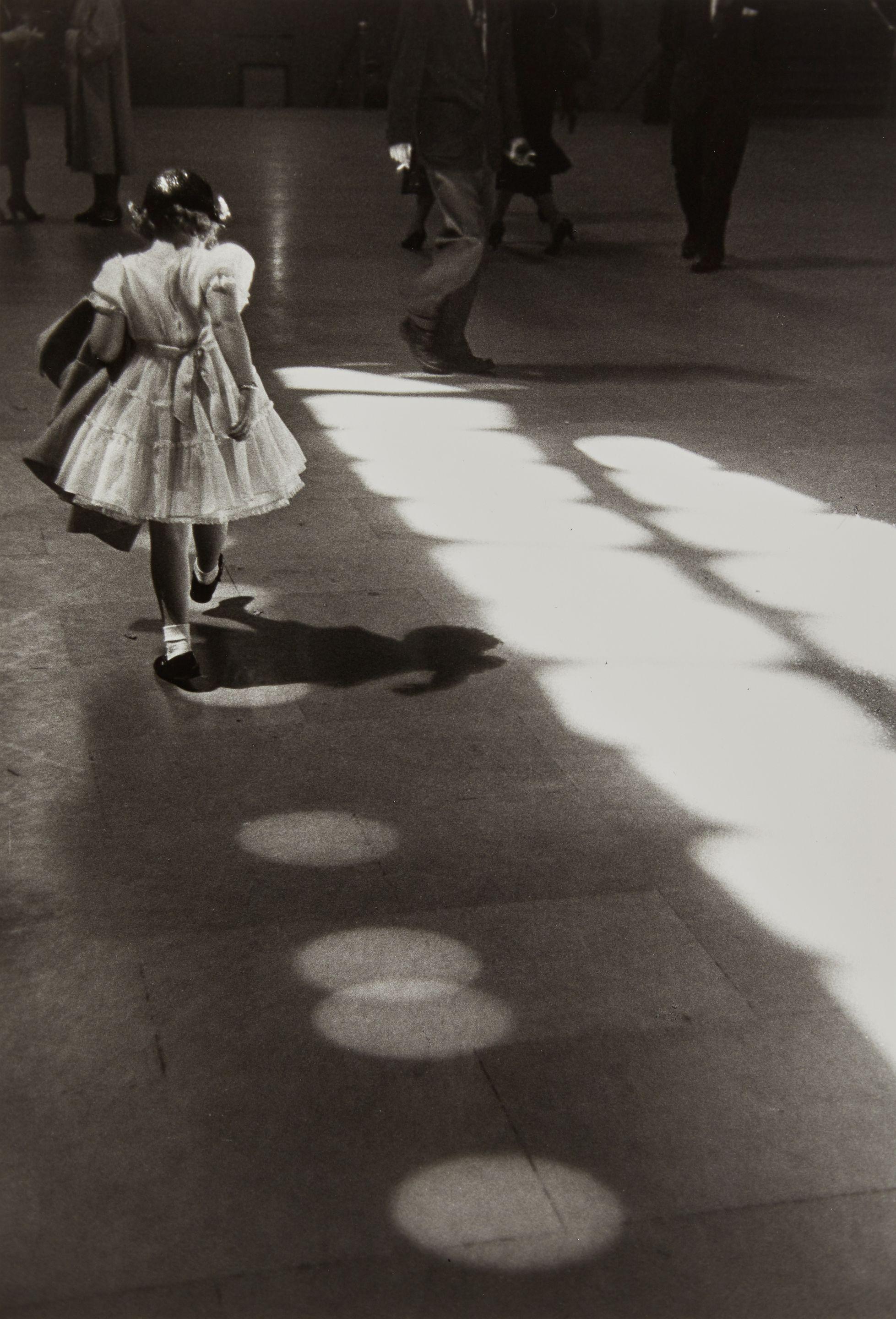 Louis Stettner - Girl Playing in Light Circles, Grand Central Station, New York