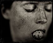 Close-up photograh of a female passing person holding something in her mouth