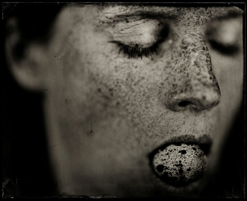 Close-up photograh of a female passing person holding something in her mouth