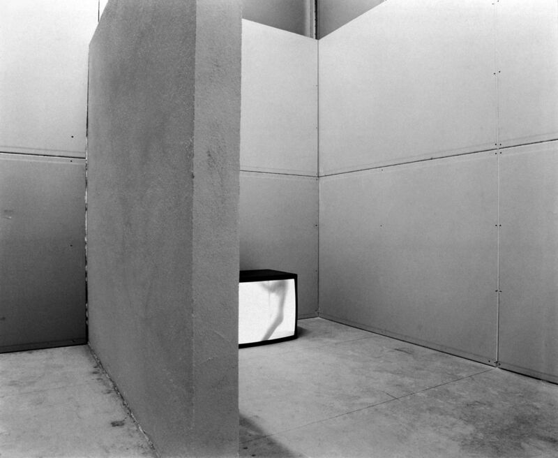 Monica Bonvicini, Wallfuckin’, 1995/96, 48 min, b/w video, monitor, wood panels, drywall panels, aluminum studs, bricks, plaster, white paint, door, 250 x 310 x 330 cm,