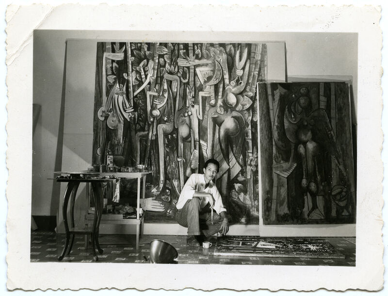 Wifredo Lam with La jungla (The Jungle) (1942–43), left, La mañana verde (The Green Morning) (1943), right, and La silla (The Chair) (1943), on the floor, in his Havana studio, 1943