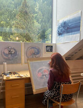 Christiane Fleissner vor dem Atelier-Fenster, zeichnend an »Organic Ornaments«, 2025