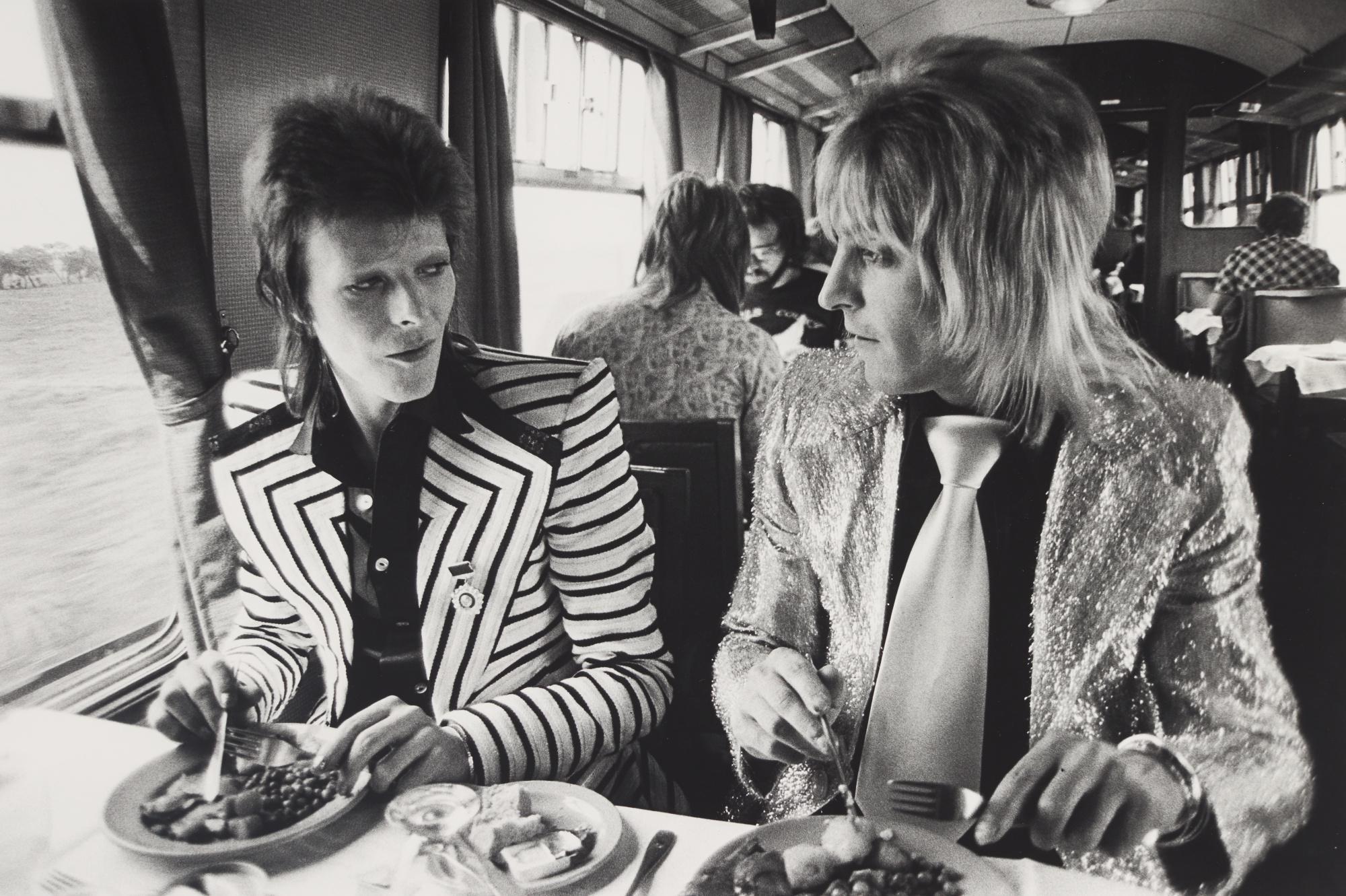 Mick Rock - David Bowie And Mick Ronson, Lunch On Train To Aberdeen, Scotland, 1973