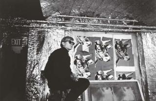 Nat Finkelstein - Andy Warhol sitting in front of his cow silkscreens