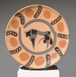 Pablo Picasso - Plat en terre cuite à décor de glaçures noir et ocre, orné au centre d\'un taureau peint dans des compartiments perlés sur la bordure; au revers inscrit MADOURA/PLEIN FEU/EDITION/PICASSO et numérotée 29/250