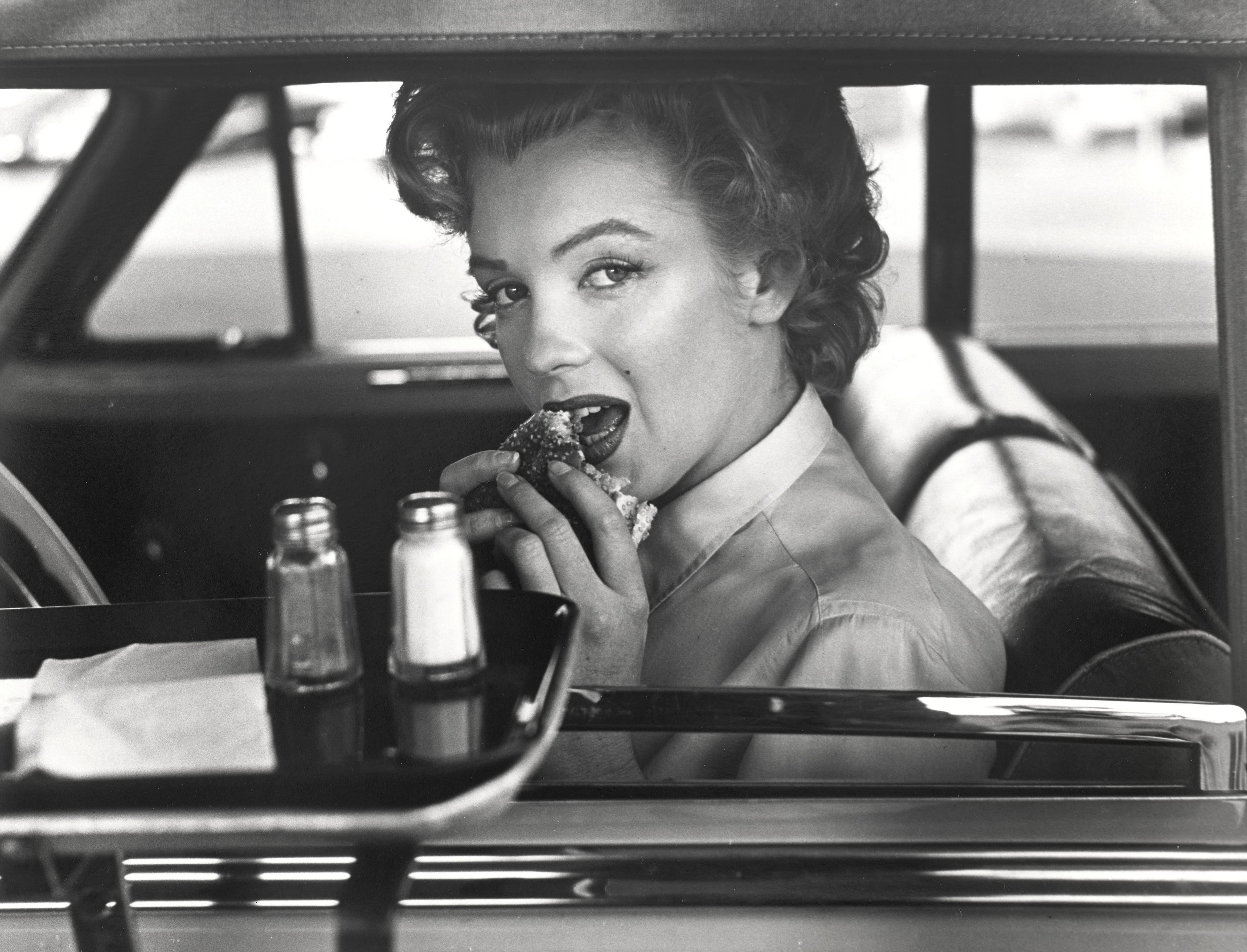 Philippe Halsman - Marilyn Monroe (At a drive-in, eating a hamburger)