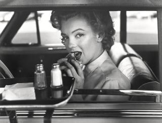 Philippe Halsman - Marilyn Monroe (At a drive-in, eating a hamburger)