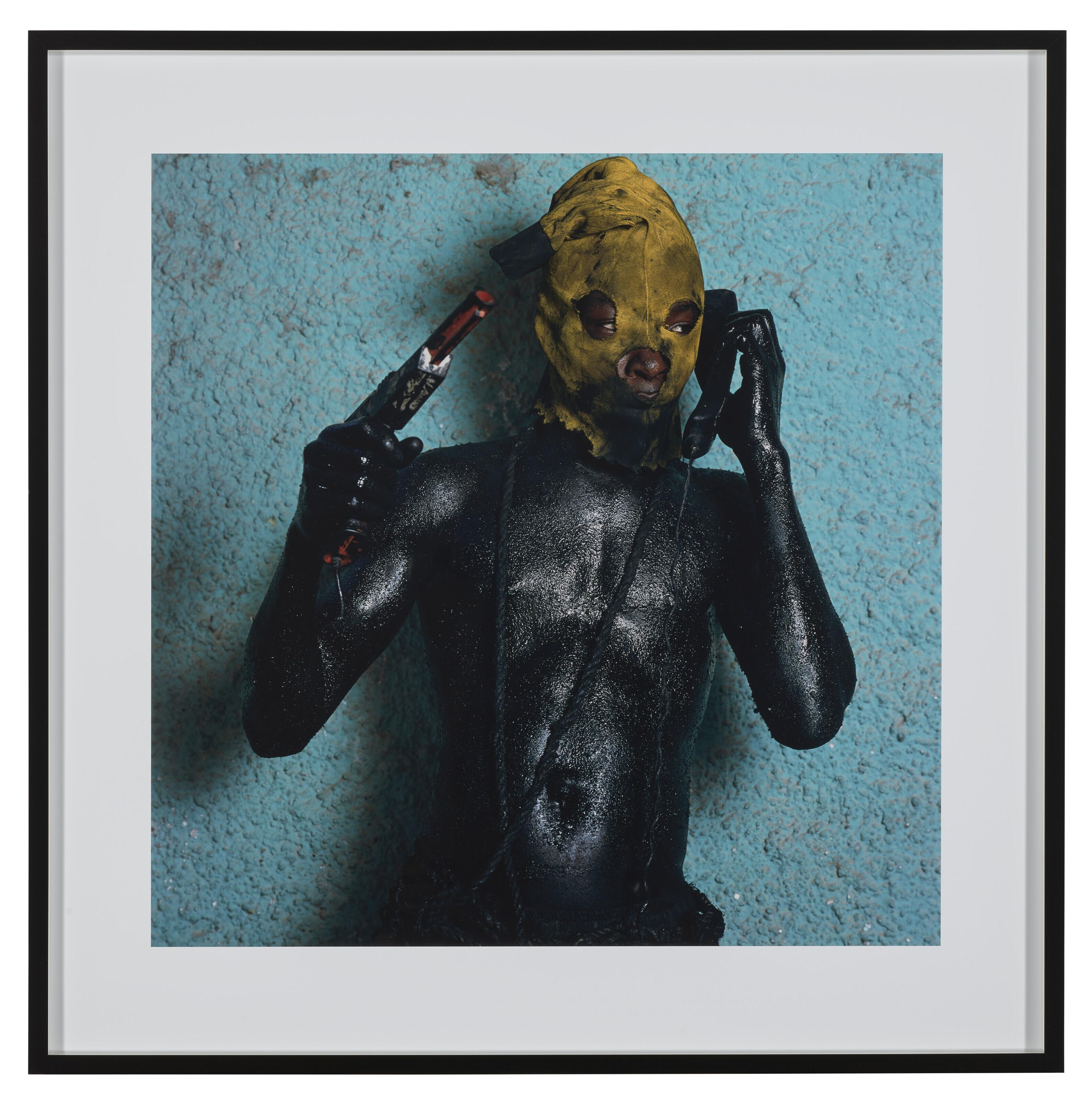 Phyllis Galembo - Man with Gun and Phone, Jacmel, Haiti, 2004