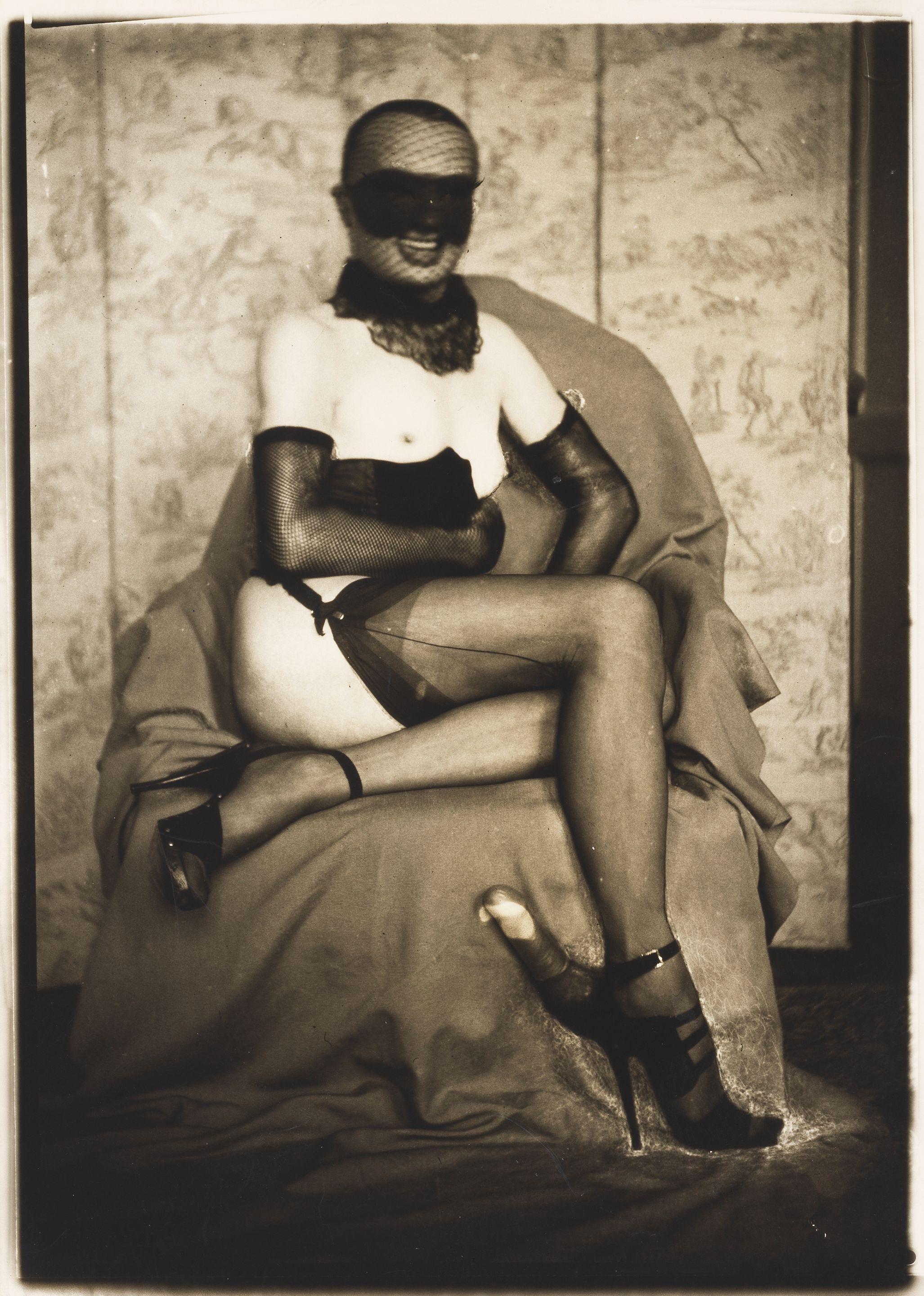 Pierre Molinier - Autoportrait à l\'éperon d\'amour et au loup, assis devant le paravent.