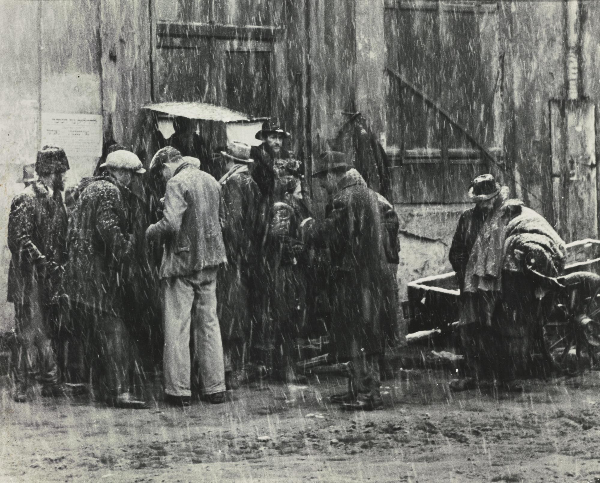 Roman Vishniac - \'Children Of Want And Fear\' (The Notice On The Wall Says Come Celebrate Chanukah.  These Men Are Selling Old Clothes, Kazimierz, Cracow)