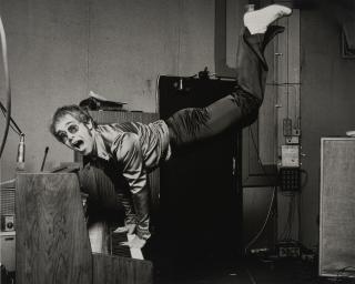 Terry O\'Neill - Elton John Performing a Handstand, 1972