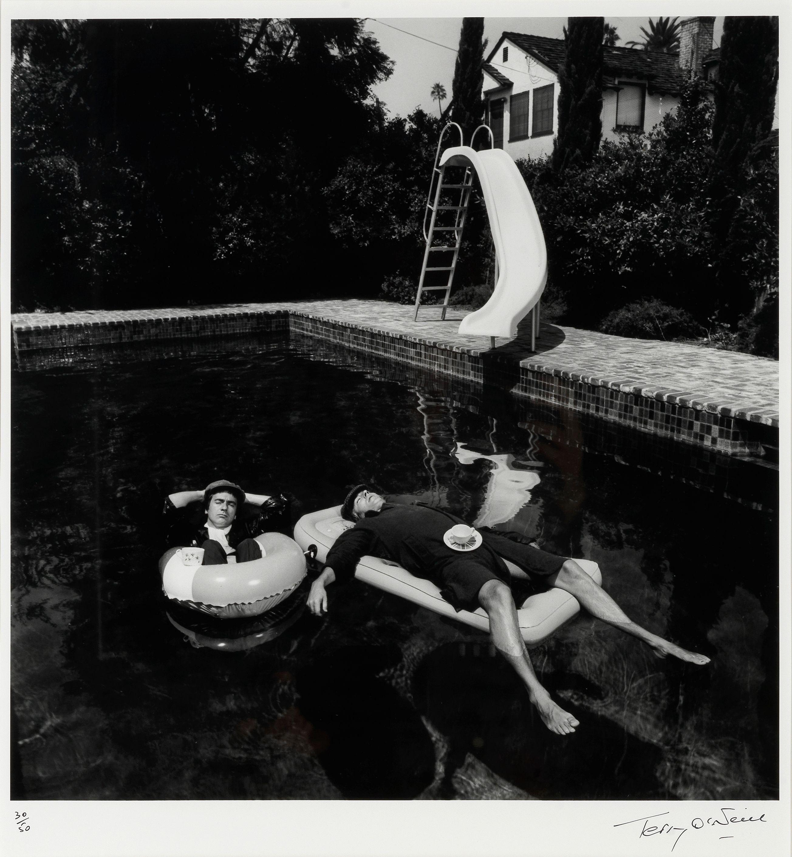 Terry O\'Neill - Peter Cook and Dudley Moore Relaxing in a Beverly Hills Swimming Pool While in Costume as The Character \'Pete\' and \'Dud\', 1975, printed later,