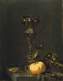 Willem Kalf - A steeple cup with upturned cover, a glass of wine, an orange and a knife on an Oriental rug on a draped marble ledge